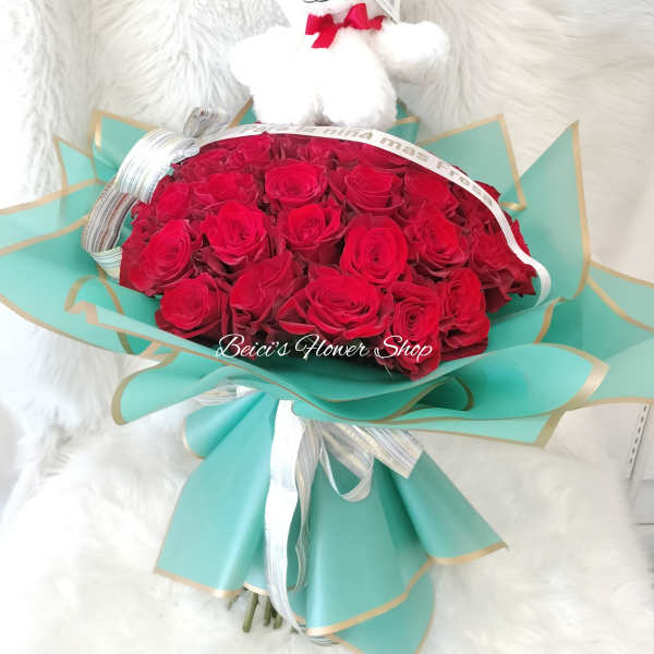 Red rose bouquet with a white teddy bear on top