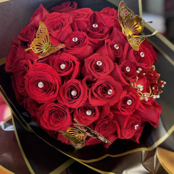 Bouquet of red roses with gold butterfly decorations and rhinestones