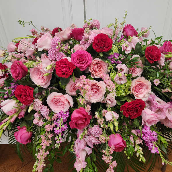 Large pink and red floral arrangement with roses and mixed blooms
