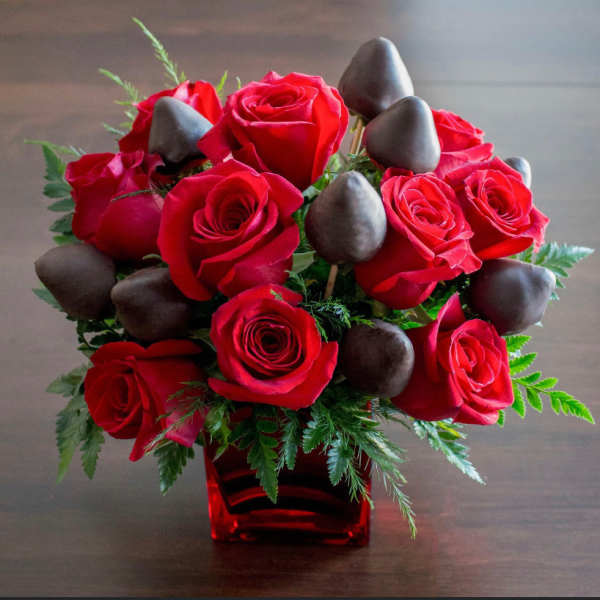 Red roses with chocolate-covered strawberries in a red vase