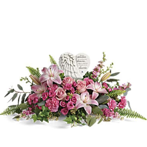 Pink lilies and roses arranged around a memorial heart plaque