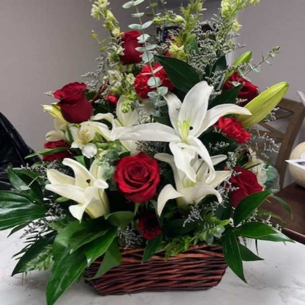 Basket arrangement of red roses and white lilies
