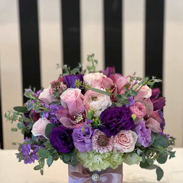 Pink and purple bouquet in a decorated round box