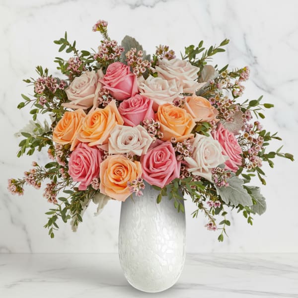 Bouquet of pink, peach, and white roses in a white vase