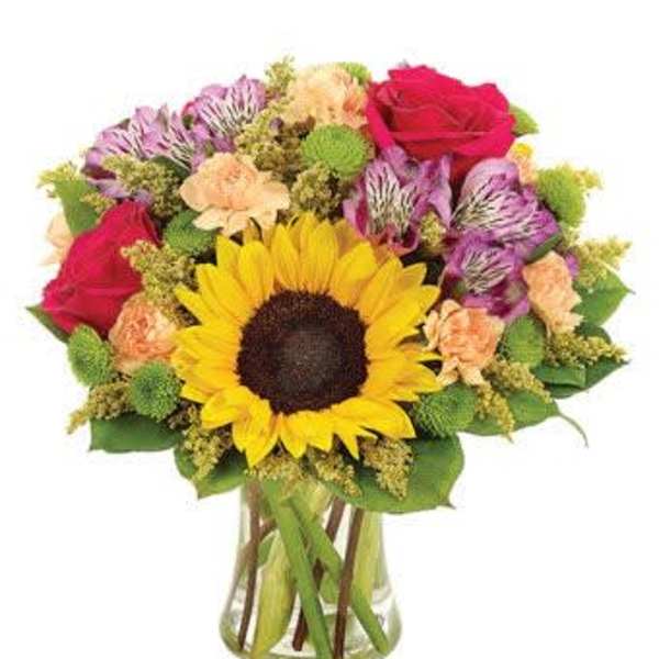 Bouquet with a sunflower, roses, and alstroemeria in a glass vase