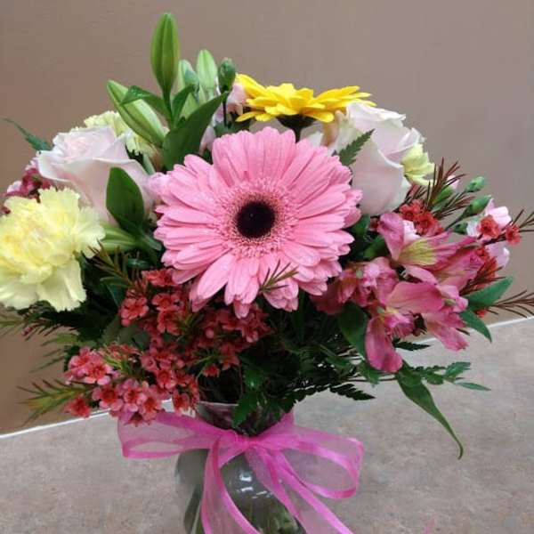 Mixed bouquet with pink gerbera daisies in a glass vase