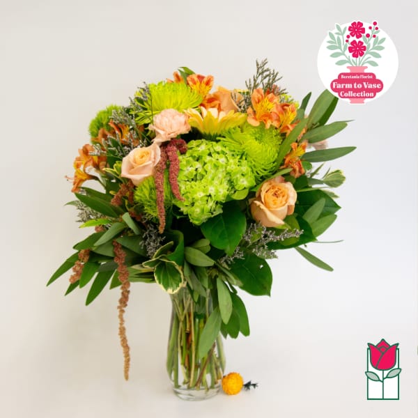 Mixed bouquet of peach roses and green chrysanthemums in a glass vase