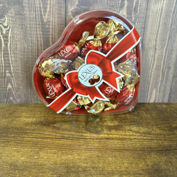 Heart-shaped box of wrapped chocolates with a red ribbon