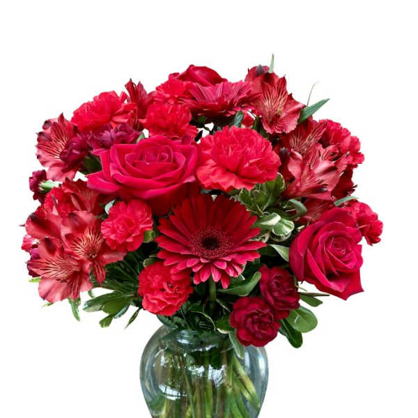 Red mixed flower bouquet in a clear glass vase
