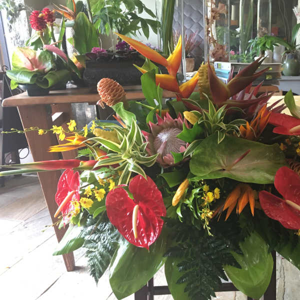 Tropical floral arrangement with red anthuriums and orange bird-of-paradise blooms
