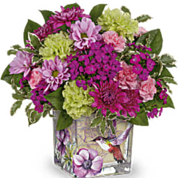 Mixed pink and green flower arrangement in a square glass vase