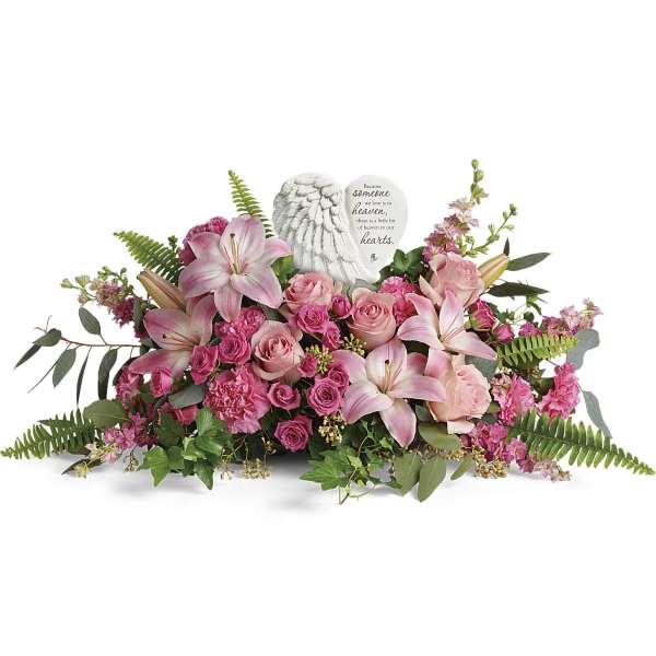 Pink lilies and roses arranged around a memorial angel heart plaque