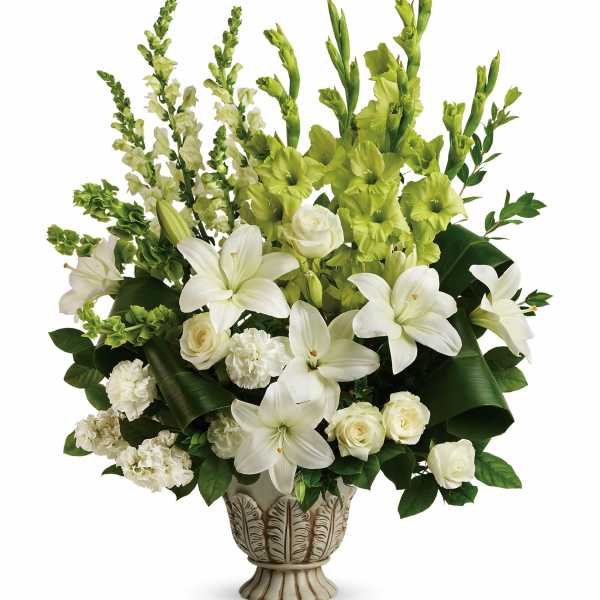 White lilies and roses arranged in a decorative vase with green flowers
