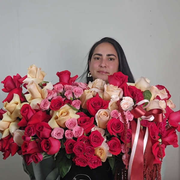Large arrangement of red, pink, and cream roses in a black hat box