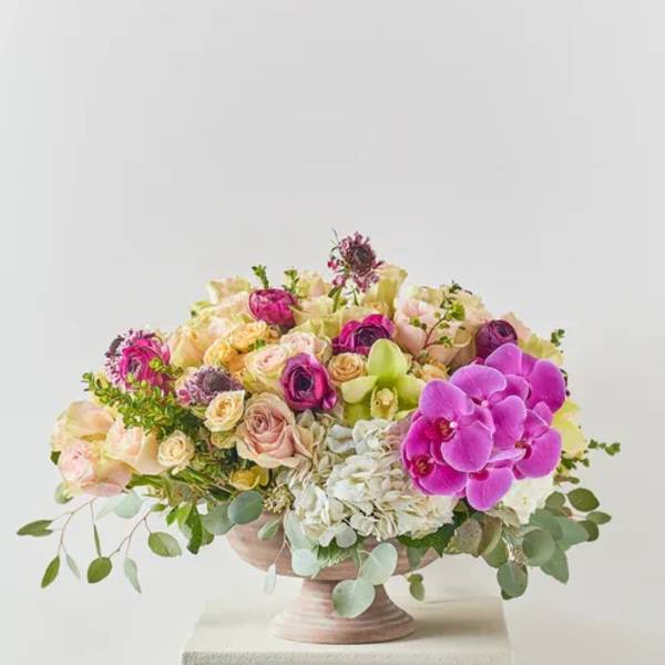 Mixed pink and cream floral arrangement in a pedestal bowl