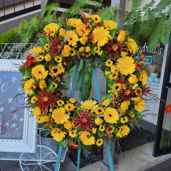 Large yellow and red floral wreath on a stand