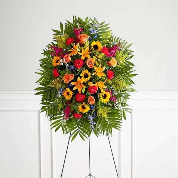 Standing floral spray with bright mixed flowers on a black easel