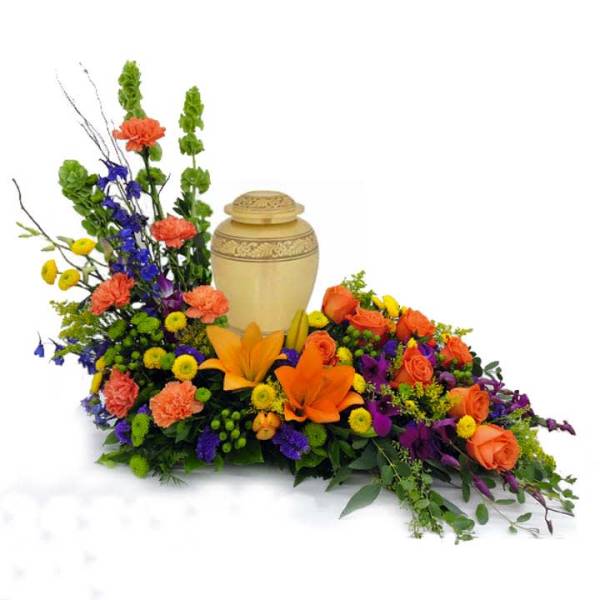 Colorful floral urn arrangement with a beige cremation urn in the center