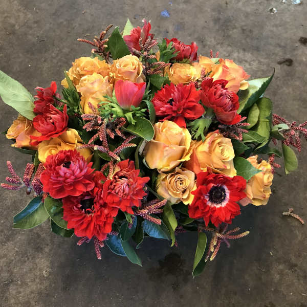 Bouquet of red and orange flowers with green leaves