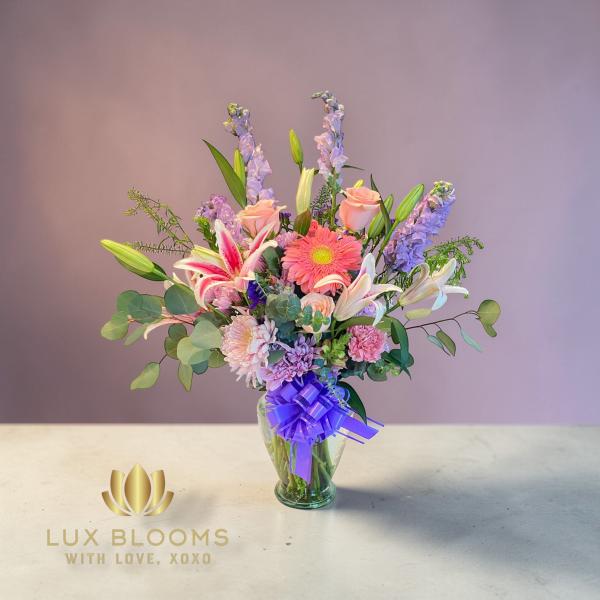 Mixed bouquet in a glass vase with lilies, gerbera daisies, and roses