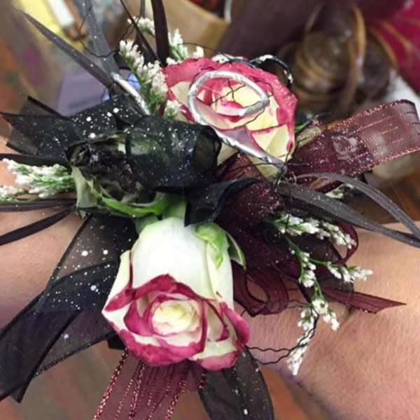 Wrist corsage with pink-and-white roses and black ribbon