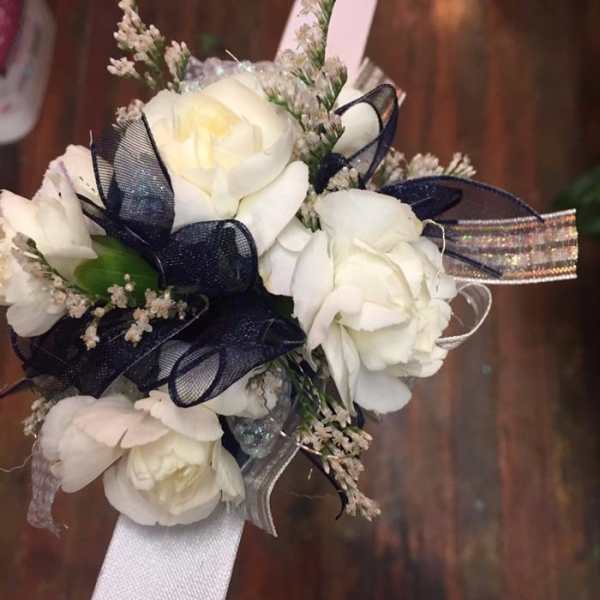 White rose corsage with navy ribbon and silver accents