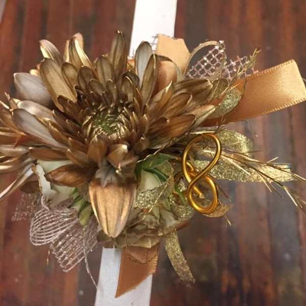 Gold-toned floral corsage with ribbon and mesh accents