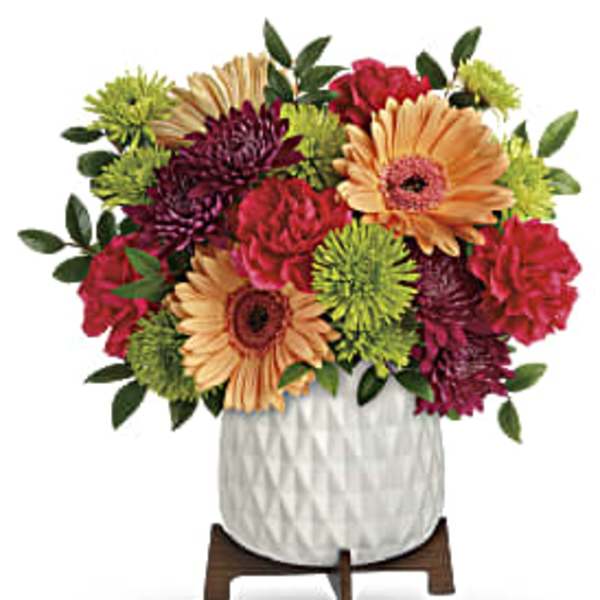 Mixed bouquet of gerbera daisies and chrysanthemums in a white vase