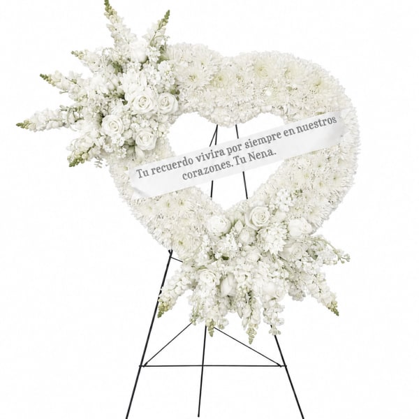 White floral heart wreath on a stand with a memorial ribbon