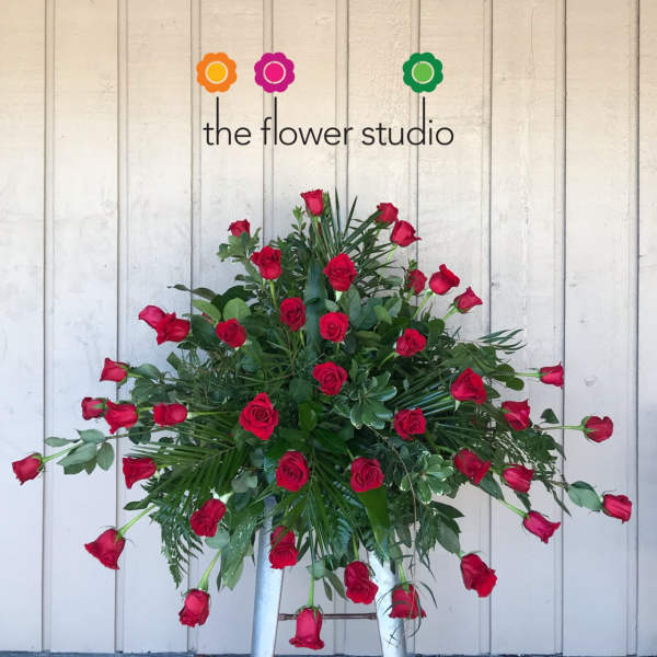 Large arrangement of red roses with greenery on a stand