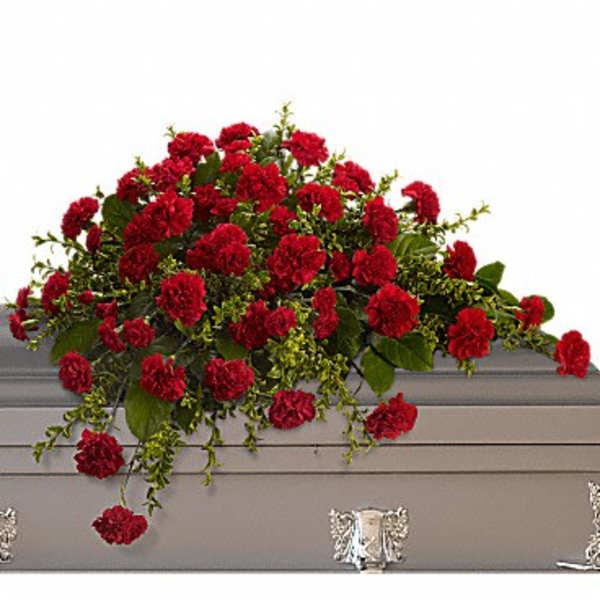 Red carnation spray on a gray casket