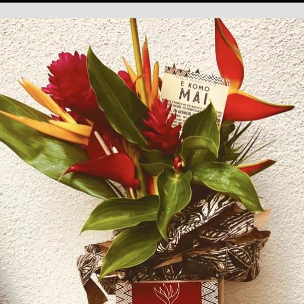 Tropical bouquet with red and orange flowers in a decorative box
