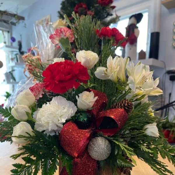 Christmas floral arrangement with red and white flowers in a wooden box