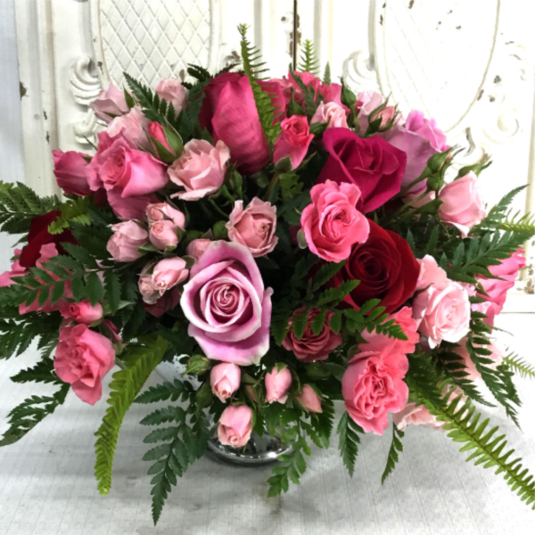 Pink and red roses arranged in a clear glass vase