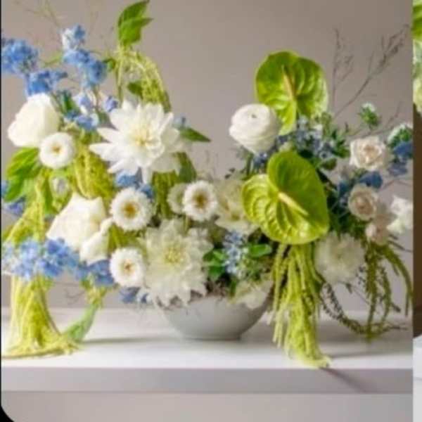 Wedding floral arrangement with white and blue flowers in a low bowl
