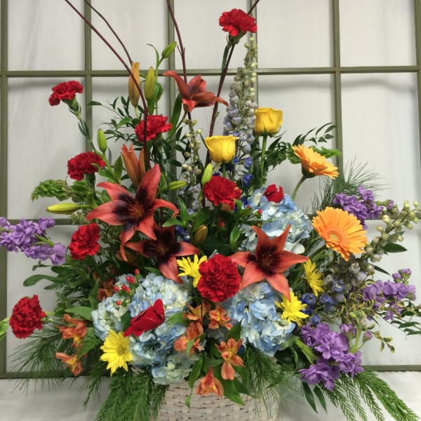 Colorful mixed flower arrangement in a woven basket
