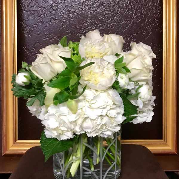 White roses and carnations in a clear glass vase