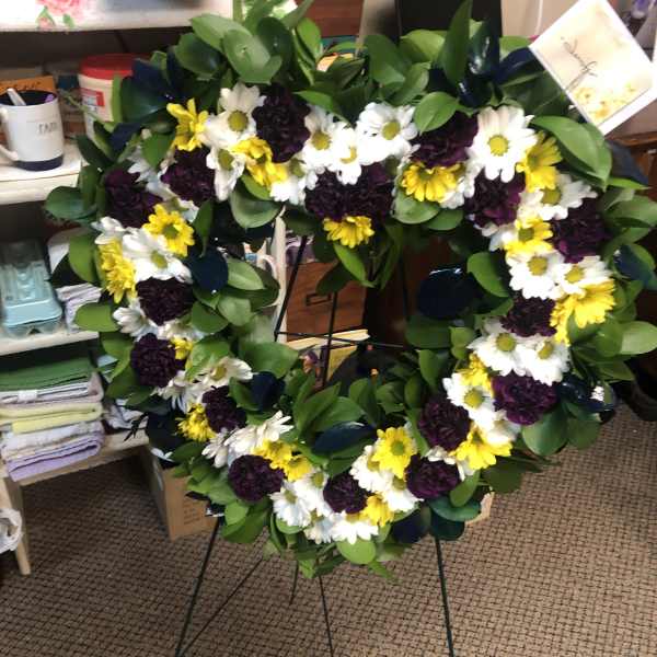 Heart-shaped floral wreath with white, yellow, and dark purple flowers