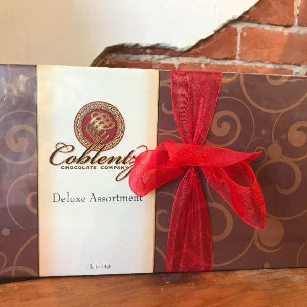 Box of assorted chocolates tied with a red ribbon