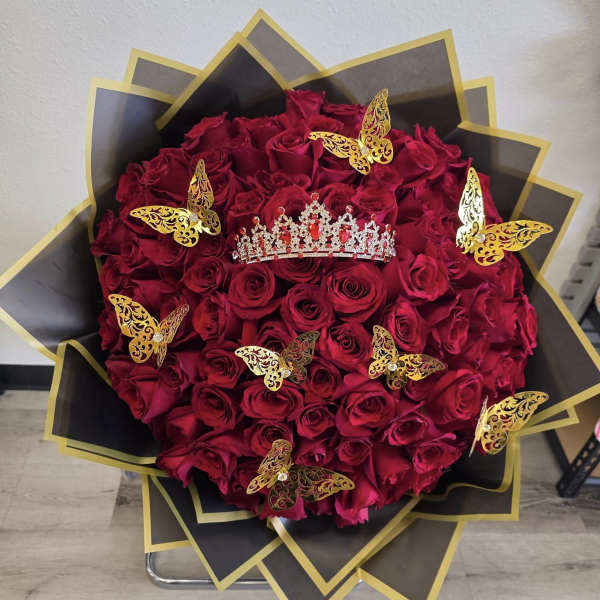 Heart-shaped bouquet of red roses with gold butterfly decorations and a tiara