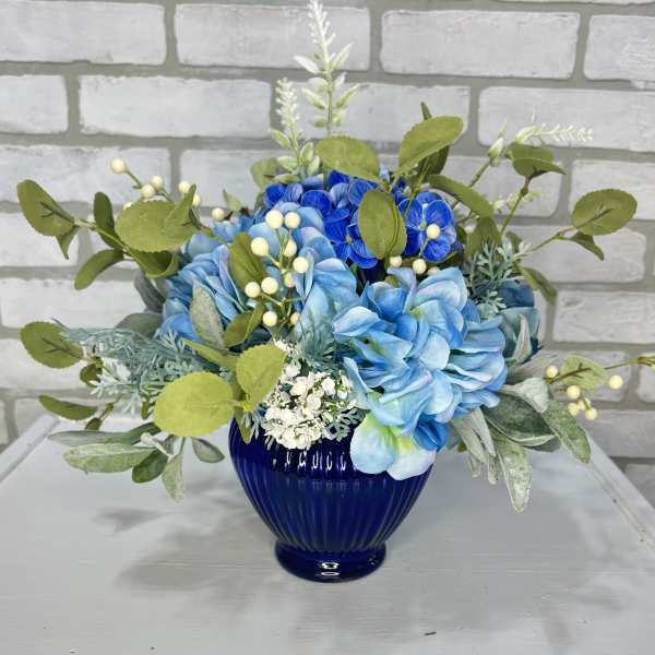 Blue and white floral arrangement in a cobalt glass vase