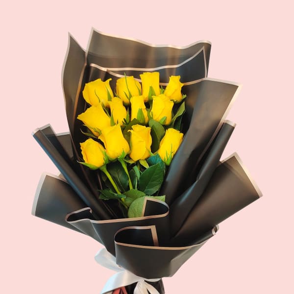 Bouquet of yellow roses wrapped in black paper