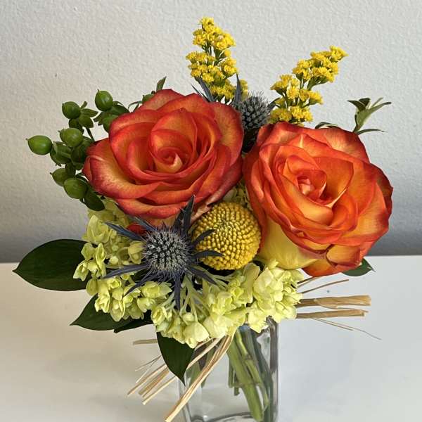 Bouquet of orange-red roses in a clear glass vase
