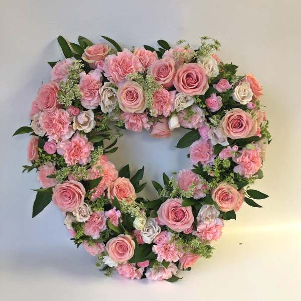 Heart-shaped floral wreath of pink roses and carnations