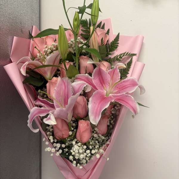 Pink lily and rose bouquet wrapped in pink paper