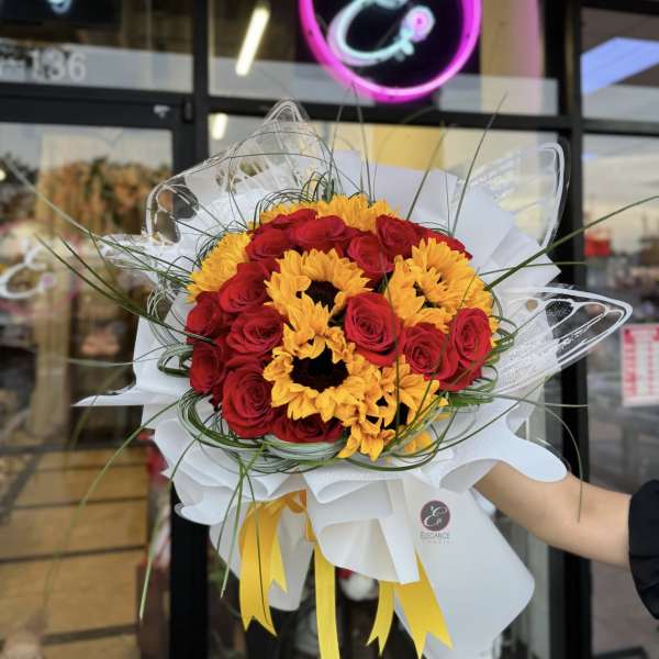 Bouquet of red roses and yellow sunflowers wrapped in white paper