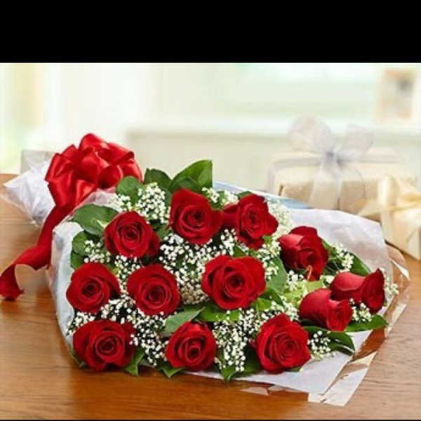 Bouquet of red roses with baby's breath wrapped in white paper