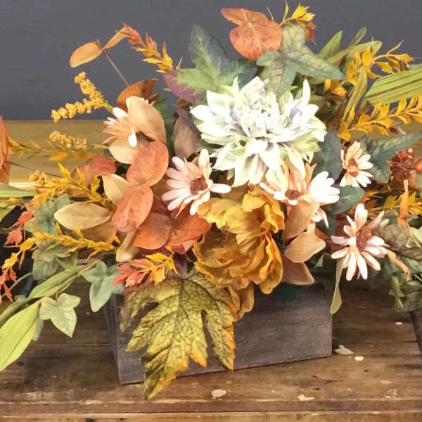Autumn floral arrangement with white and peach daisies in a wooden box