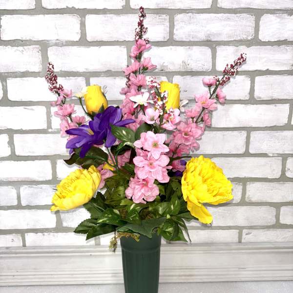 Mixed pink and yellow flowers in a tall green vase