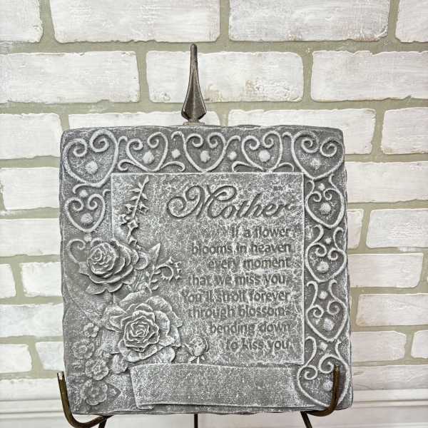 Gray memorial plaque with roses on a metal stand